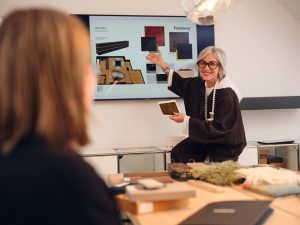 Professionelle Projektplanung bei Freisberg Wohnbedarf: Eine Beraterin präsentiert ein digitales Raumkonzept und Materialproben für eine individuelle Inneneinrichtung.